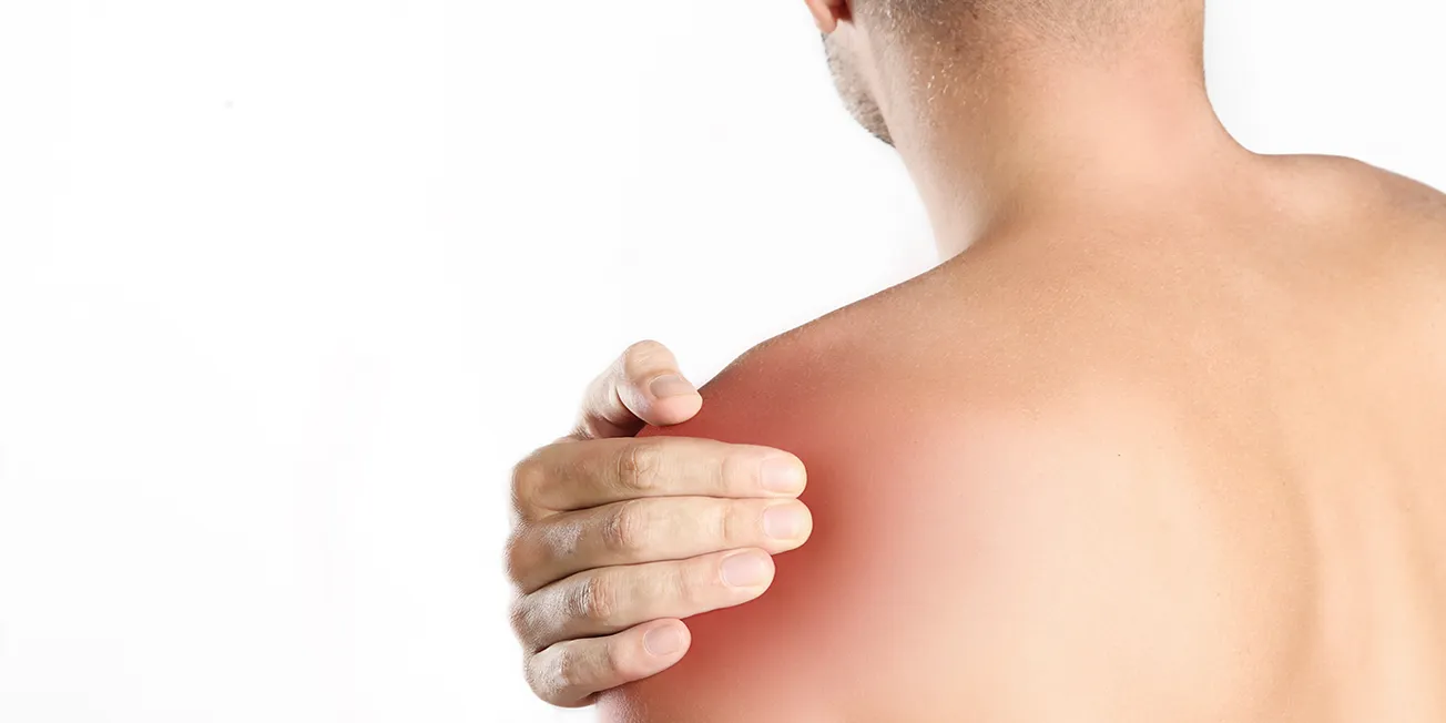 Mann med smerter i skulder.