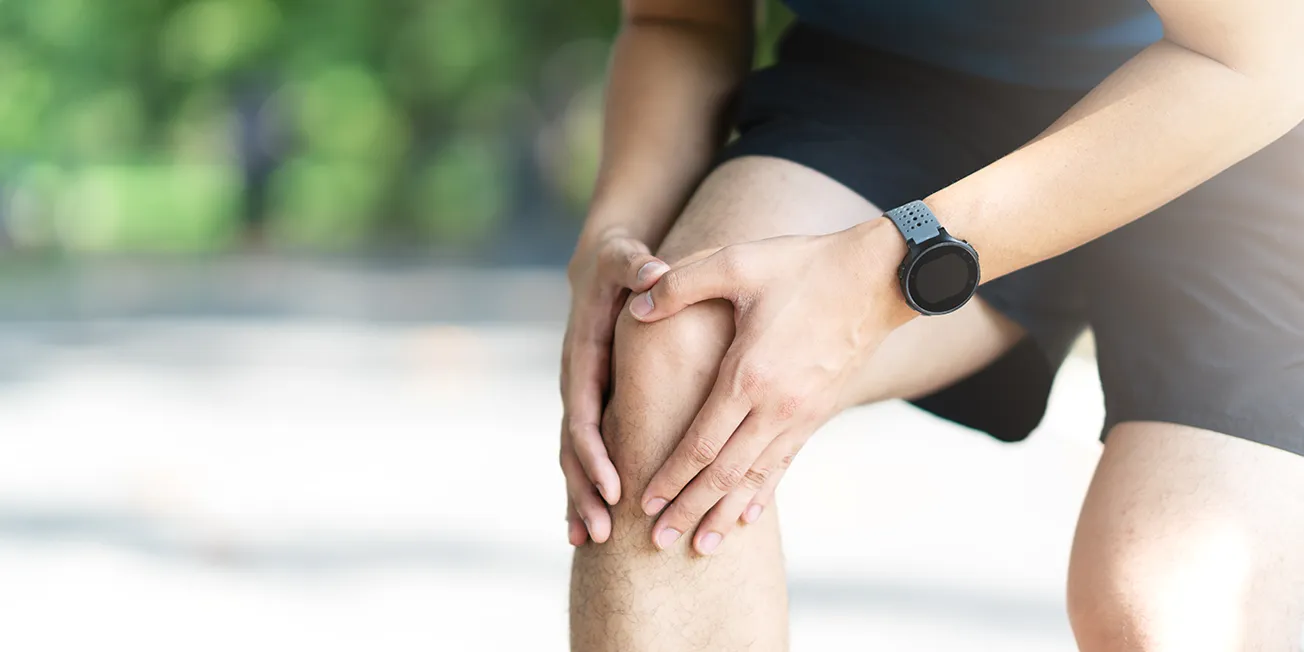 Mann med smerter i kne.