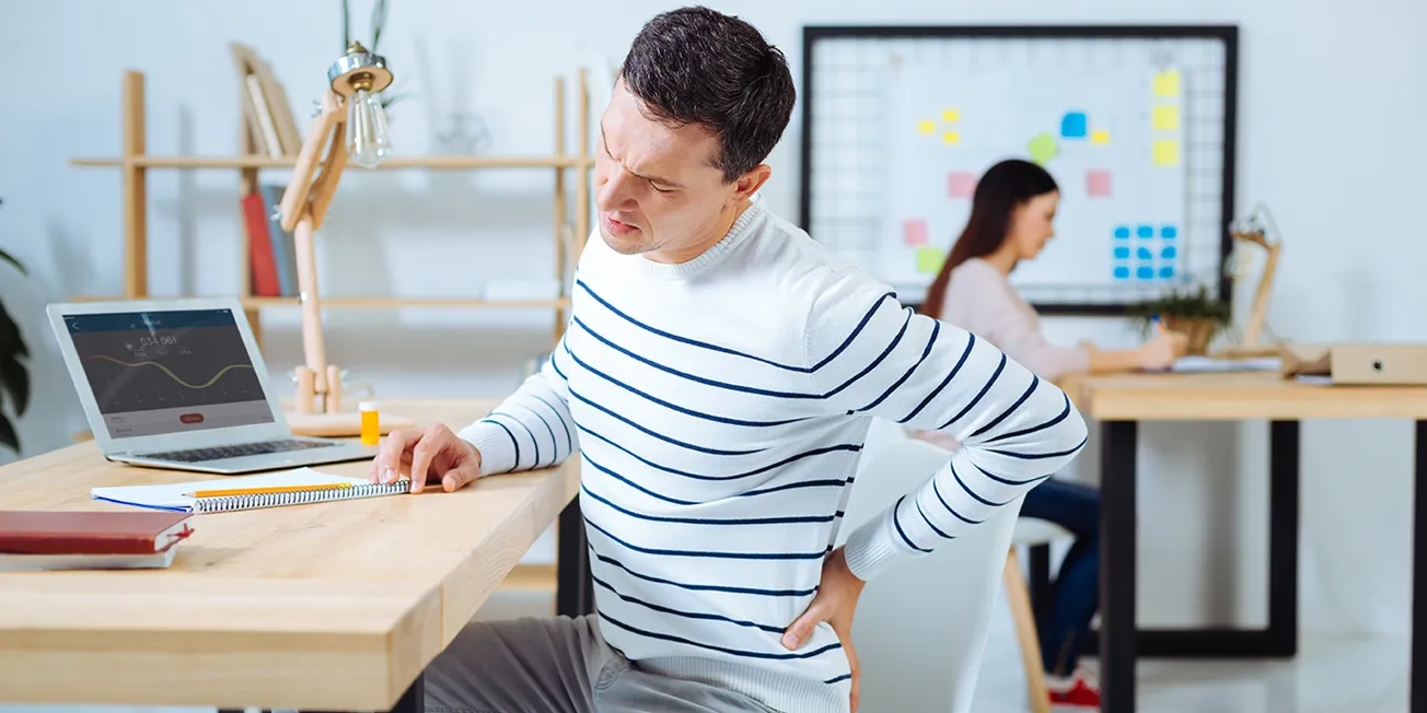 Mann med smerter i ryggen.