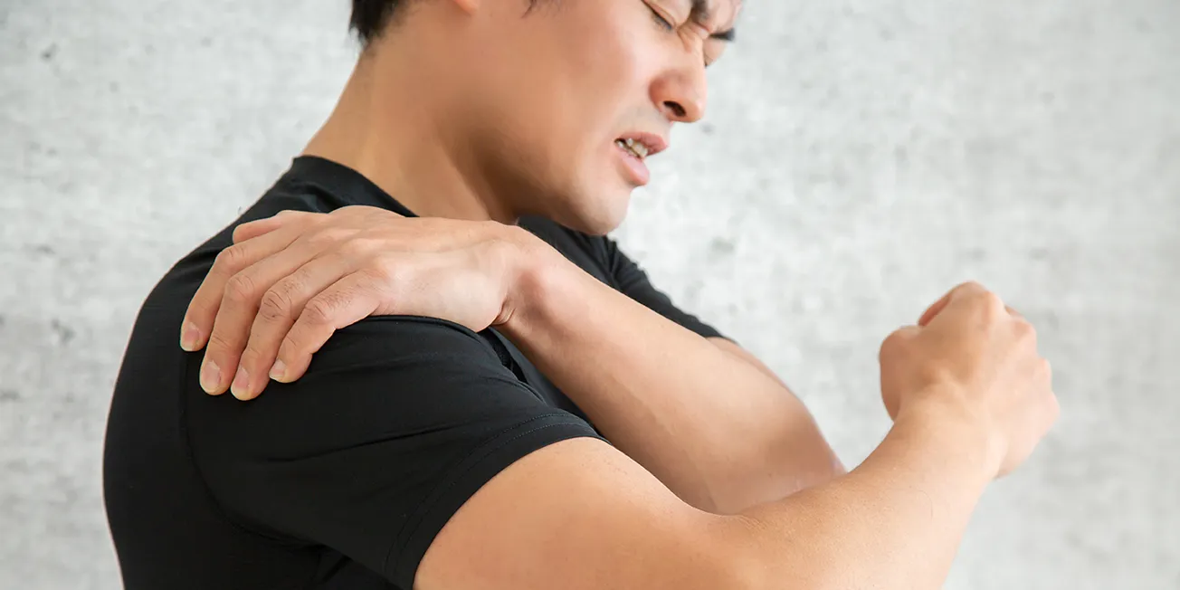 Mann med smerter i skulder.