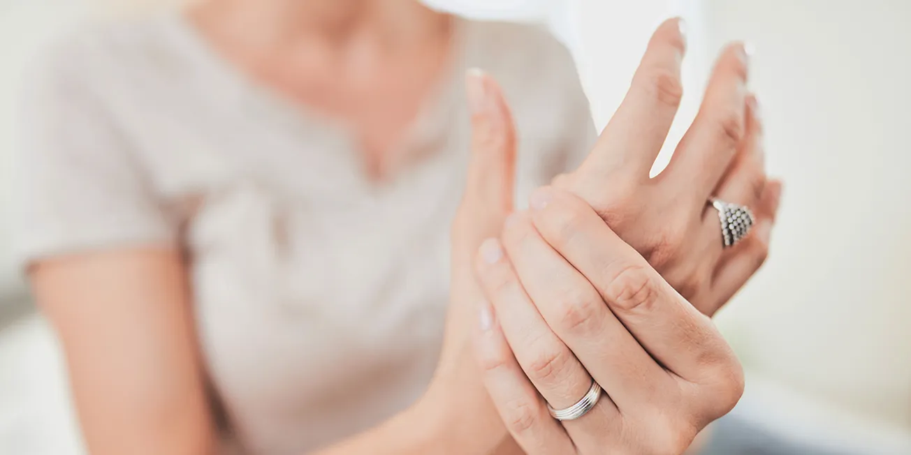 Kvinne med smerter i tommel.